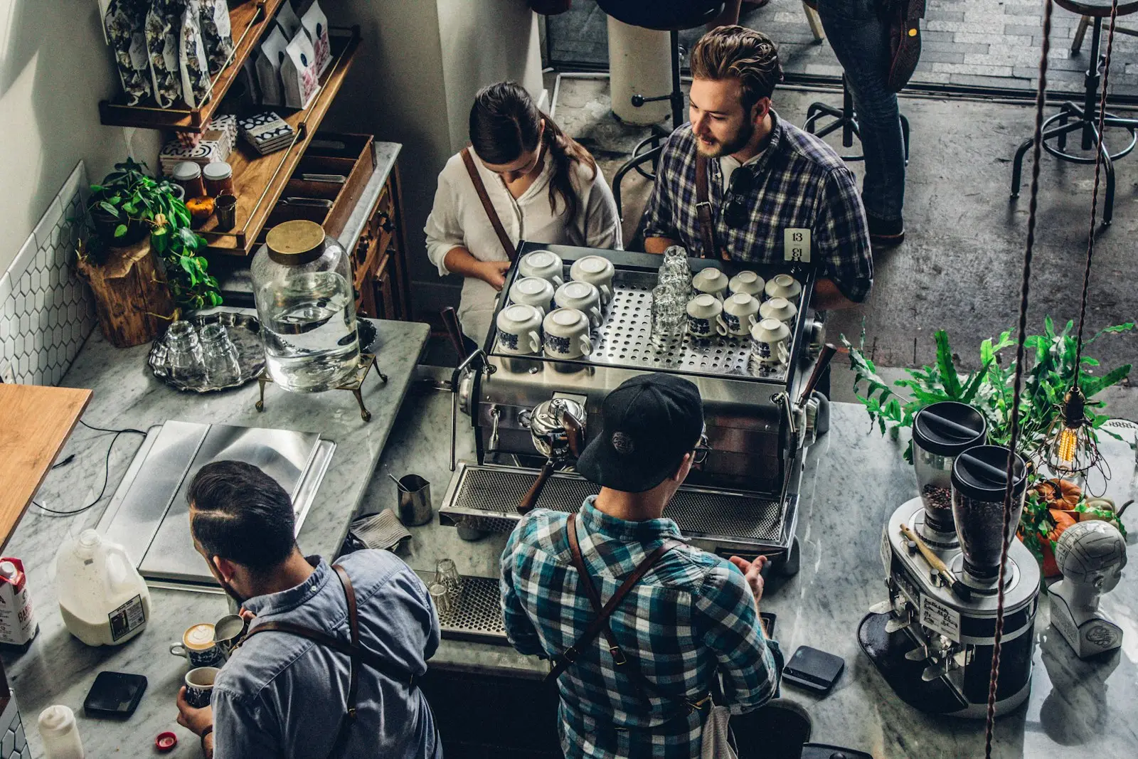 Baristas making coffee behind a busy café counter